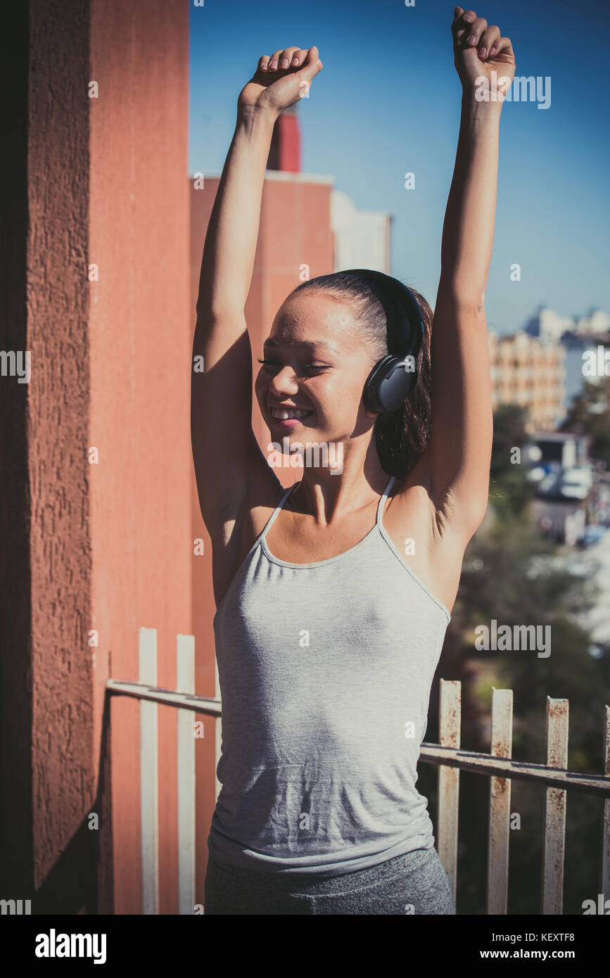 Young asian teen woman outdoor portrait closed eyes sunlight smiling with headphones portrait Stock Photo