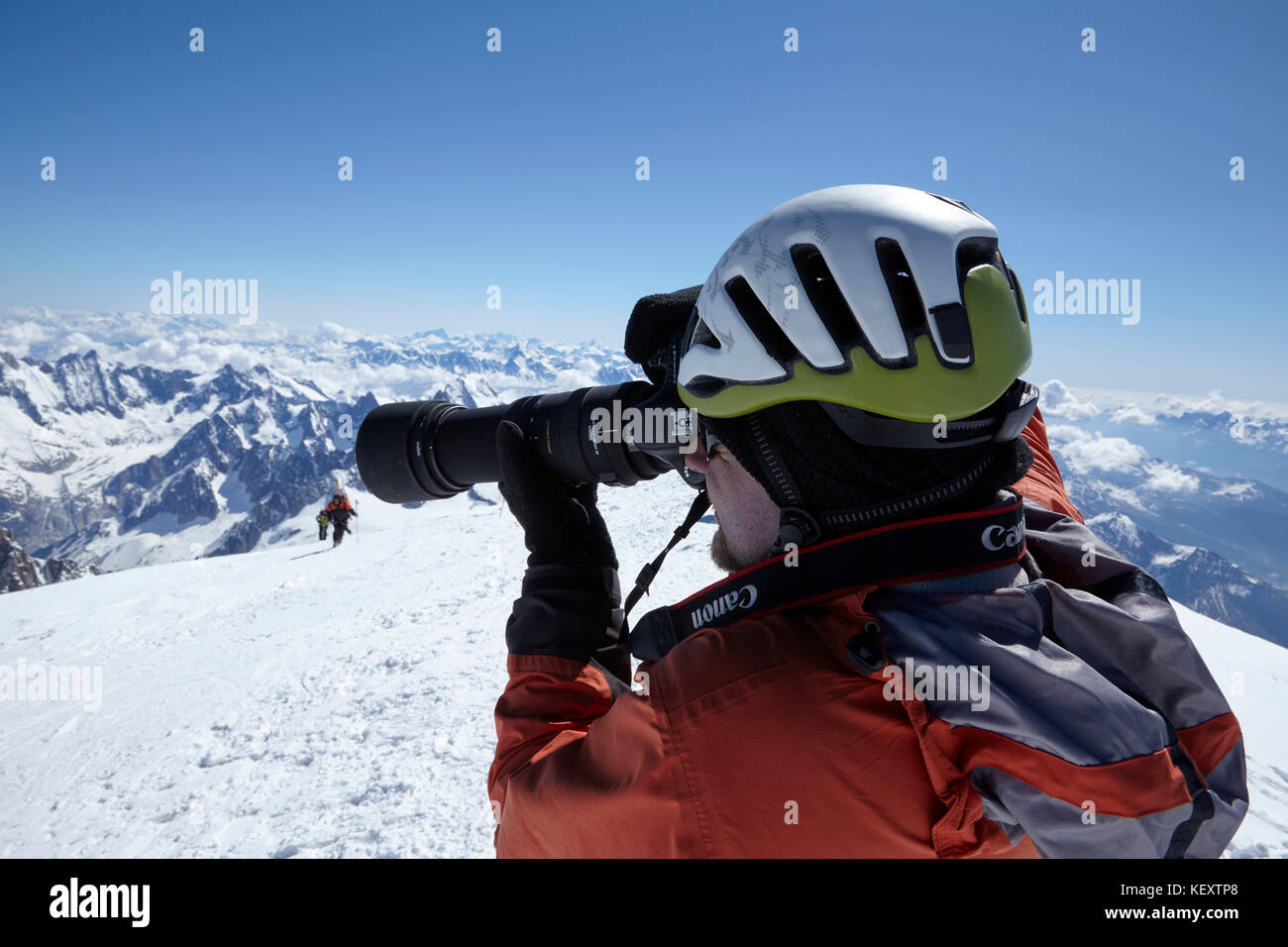 High section of man photographing snowcapped mountains, Switzerland Stock Photo