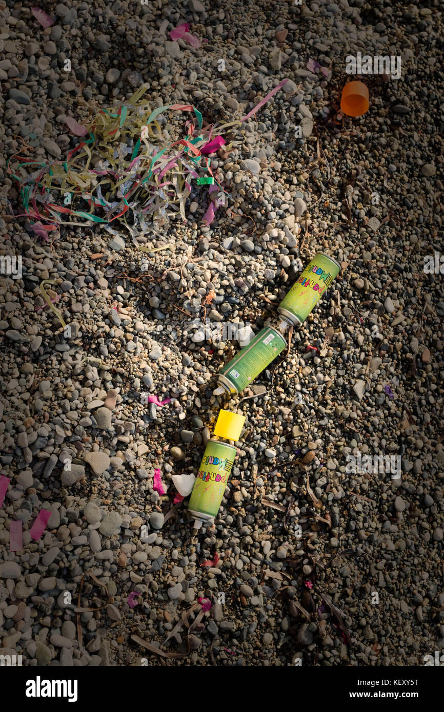 Three colourful discarded crazy string (silly string)  tins on the beach following the carnival in kato paphos, cyprus, europe Stock Photo