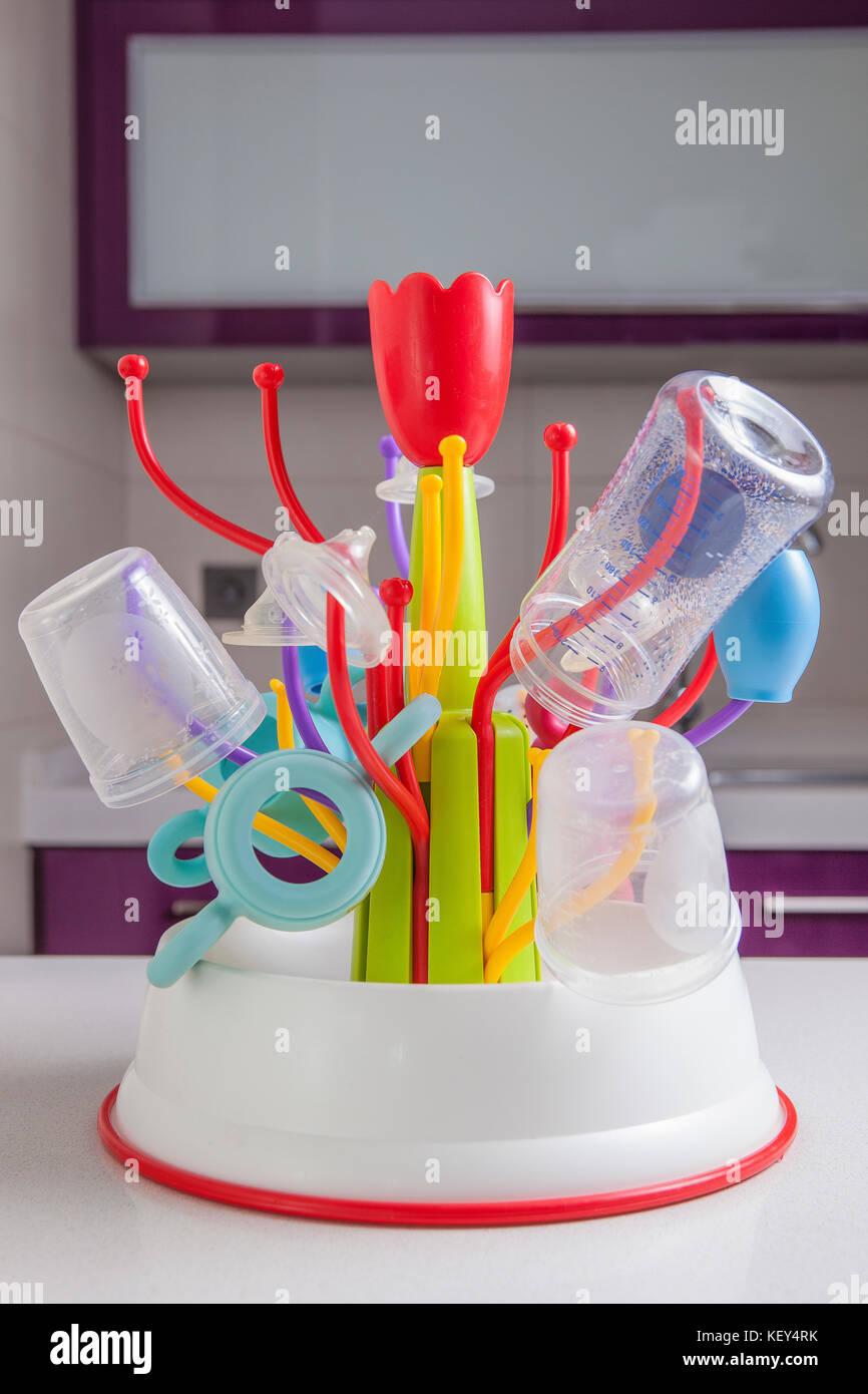 Baby drainer full of plastic tableware objects as baby bottles, nasal aspirator, milk bowls, teats and others Stock Photo