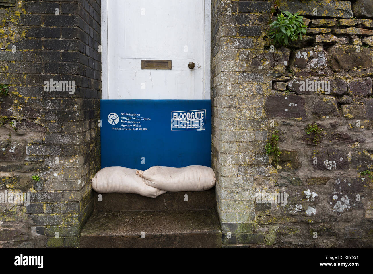 Floodgate flood prevention gate / measure in front of a door with sandbags Stock Photo