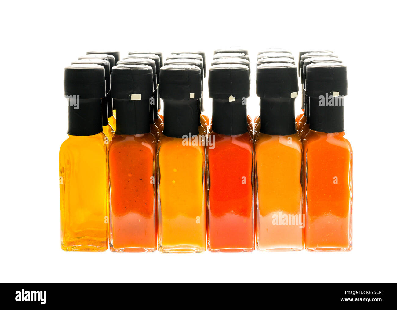 Set of Hot Chili Sauce glass bottles on white background. Different color home made hot sauce in