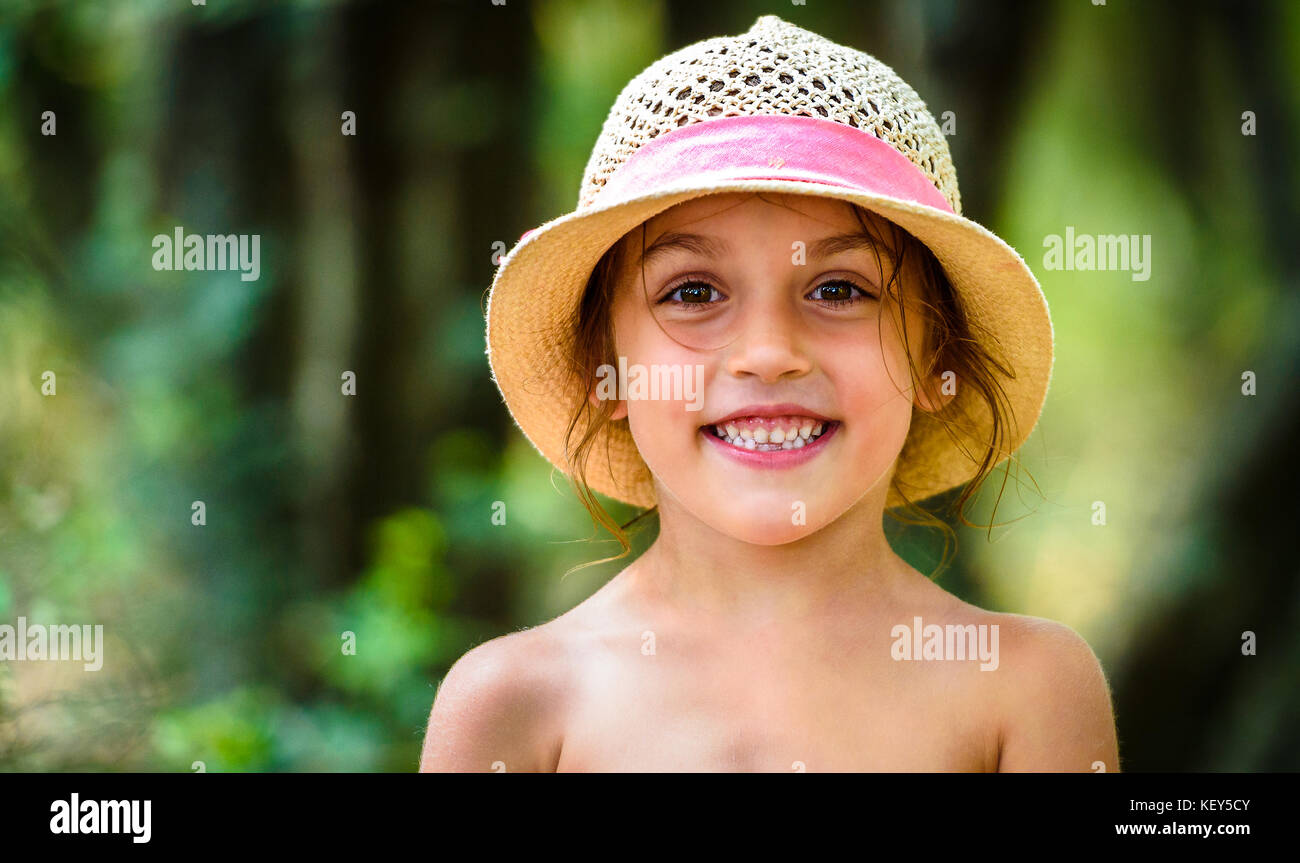 Portrait of happy girl child is smiling enjoying adopted life. Portrait of young girl in nature, park or outdoors. Concept of happy family or successf Stock Photo