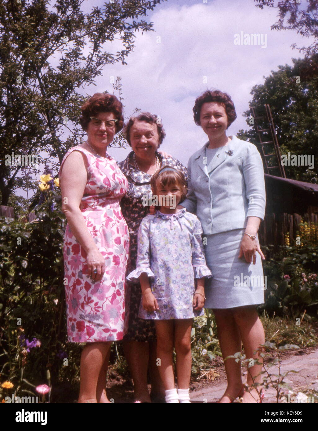 Family group in garden with 3 generations from grand-daughter to daughter and mother who is having a laugh!  August 1967. Photograph by Tony Henshaw Stock Photo
