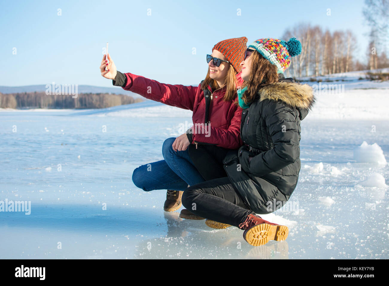 Girl taking selfie siting on a iced lake Stock Photo