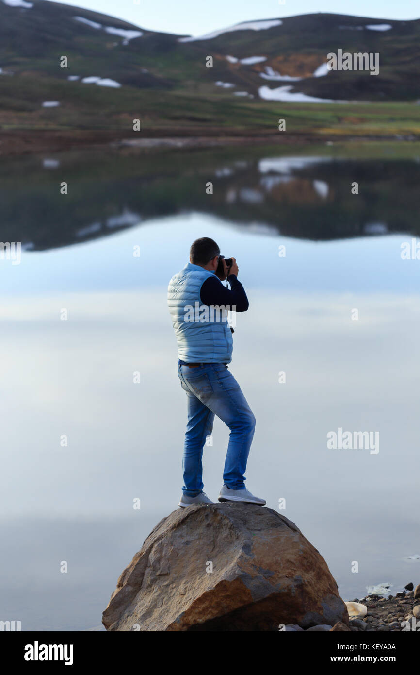 Landscape photographer photographing mountain lake Stock Photo