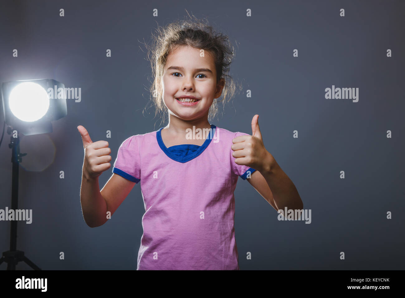 baby girl showing thumbs up sign yes Stock Photo