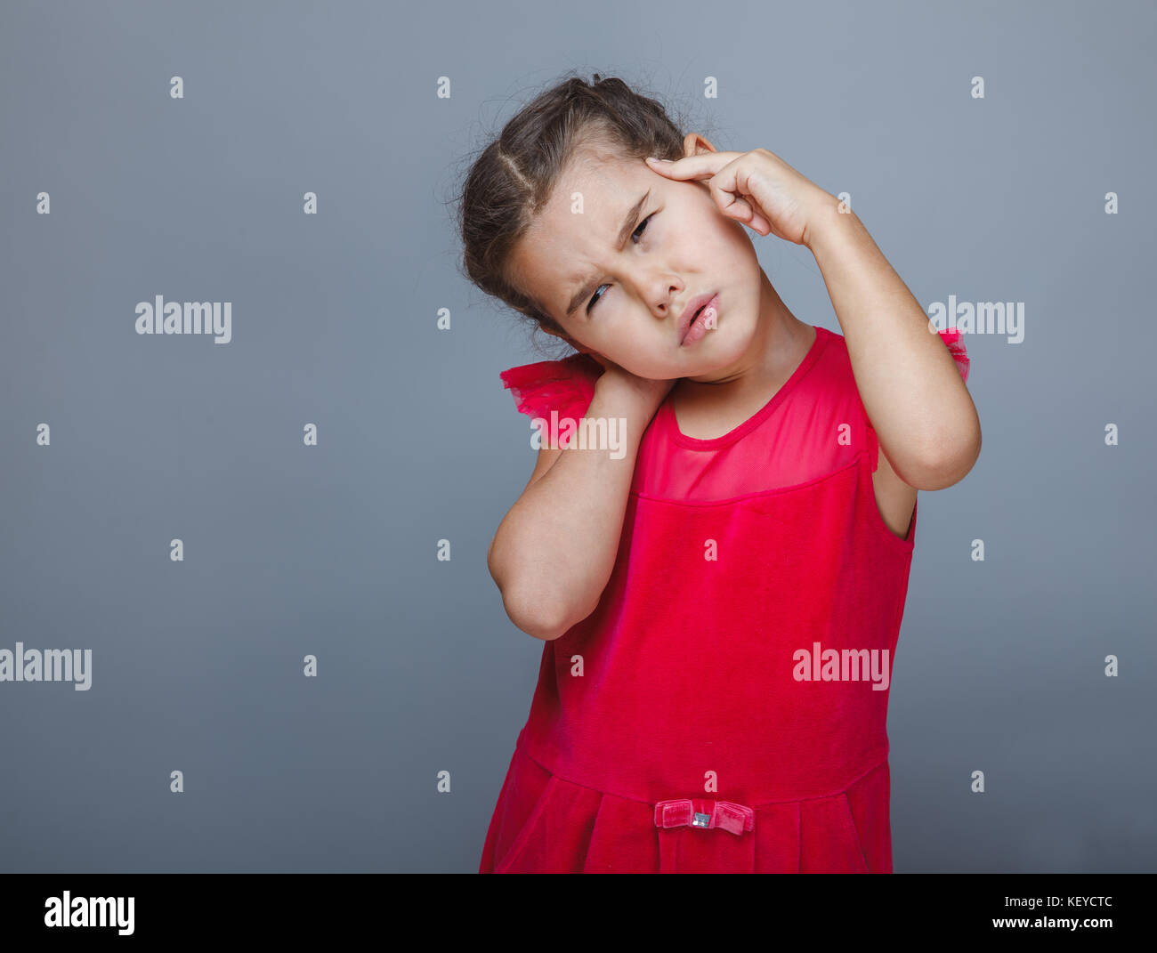 Teen girl child headache migraine holding his head on a gray bac Stock Photo