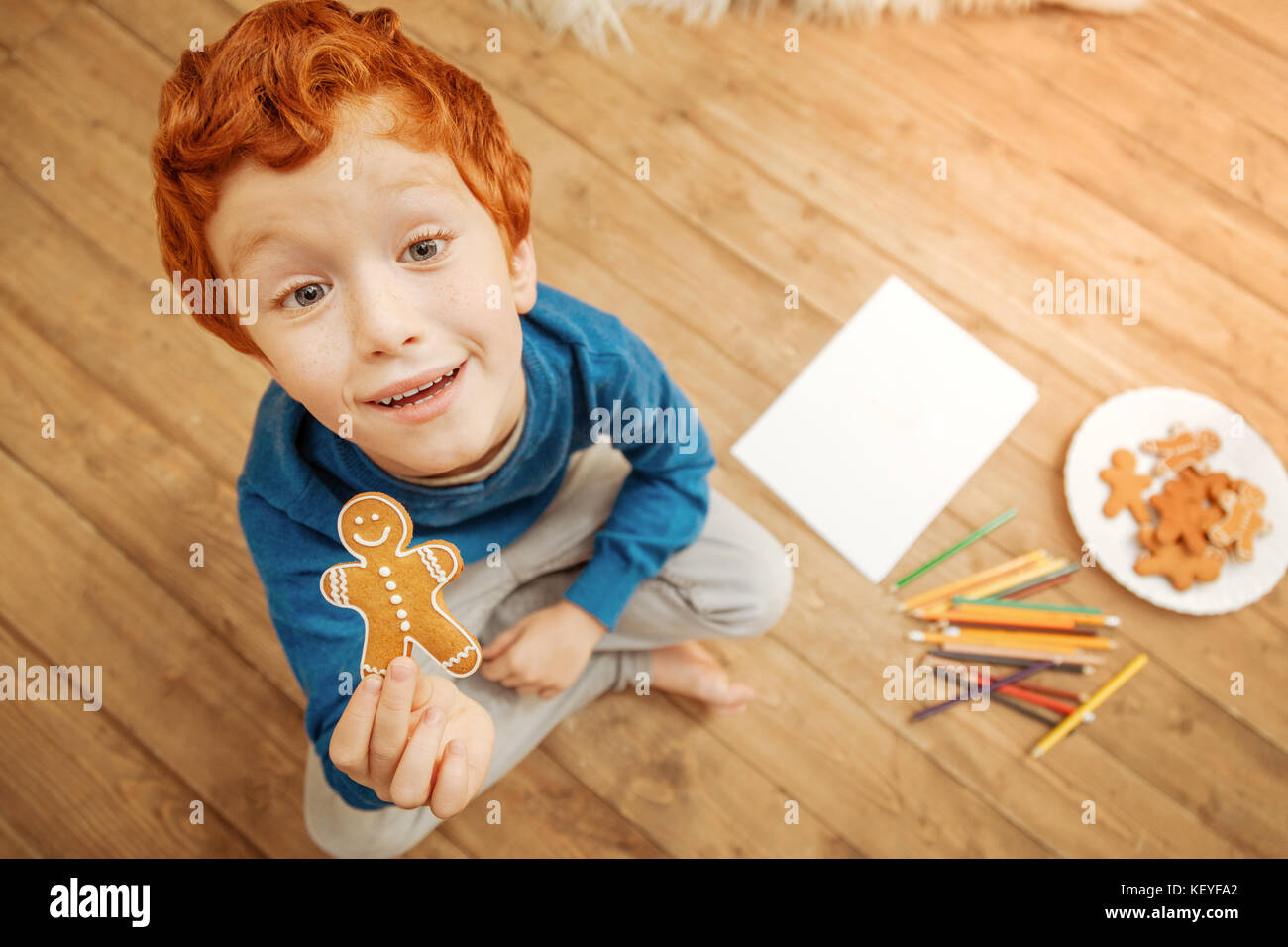 Adorable kid showing gingerbread man into camera Stock Photo