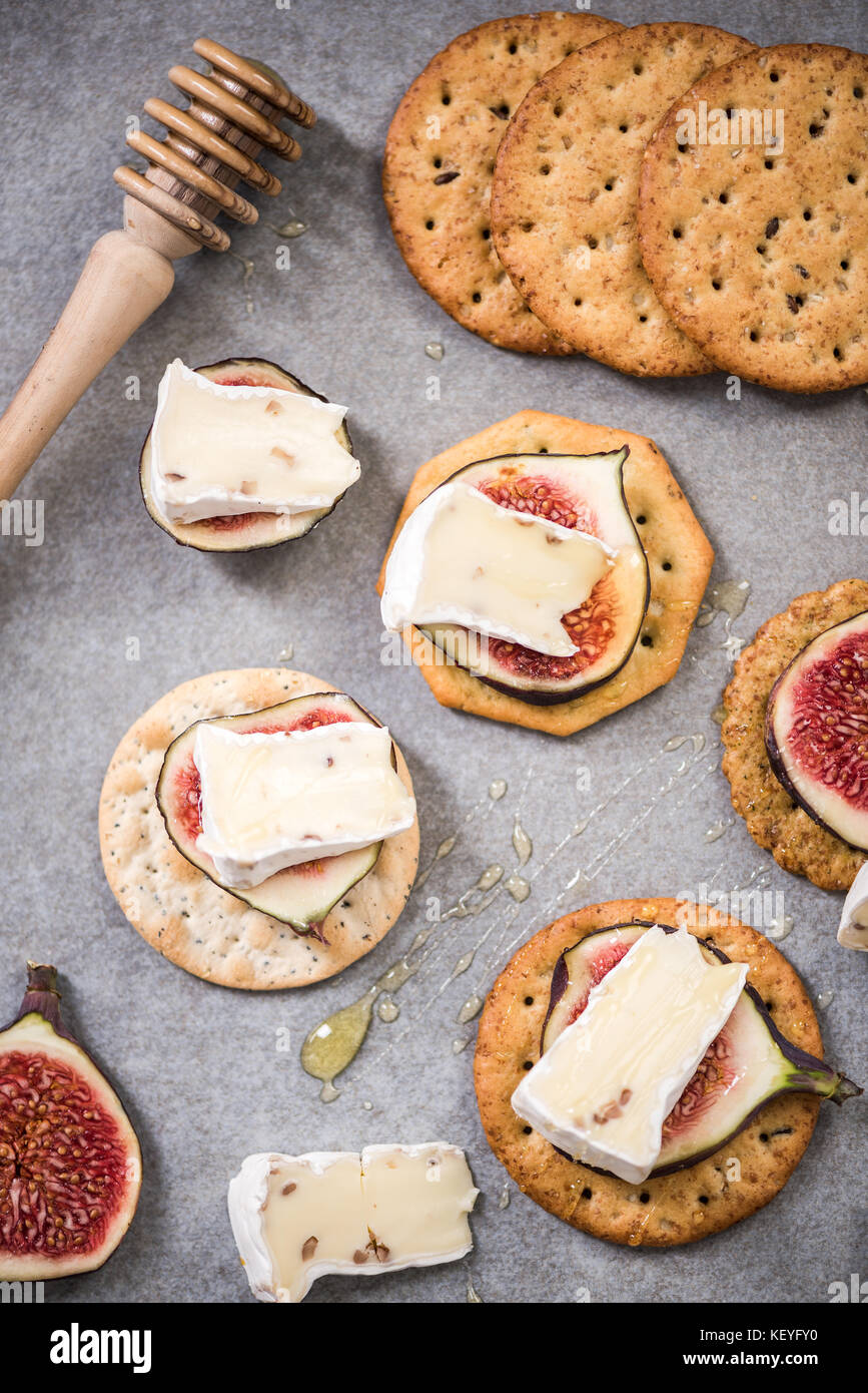 Camembert and figs on cheese crackers with honey Stock Photo Alamy