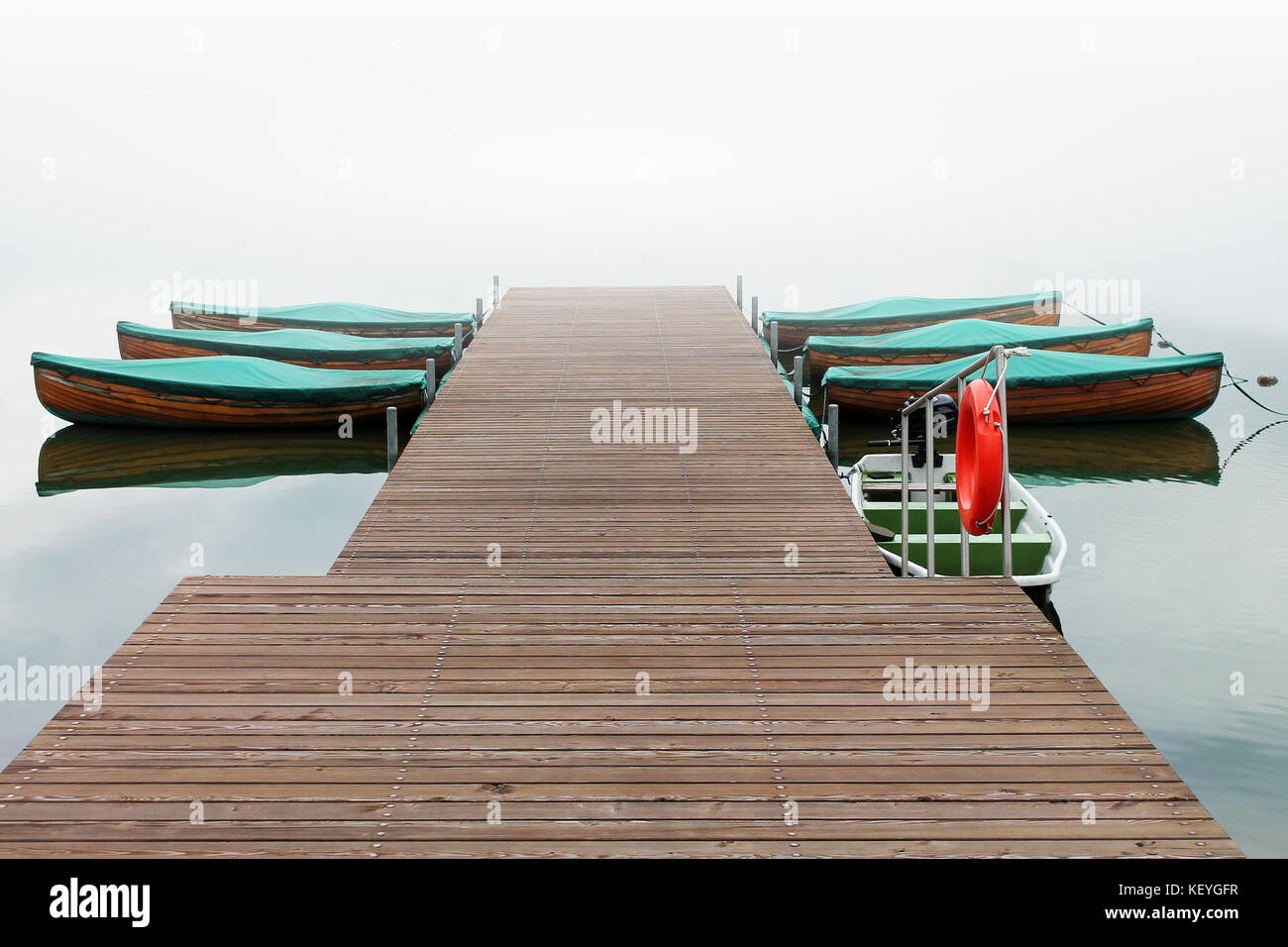 Wooden pier and boats on a water close up. Stock Photo