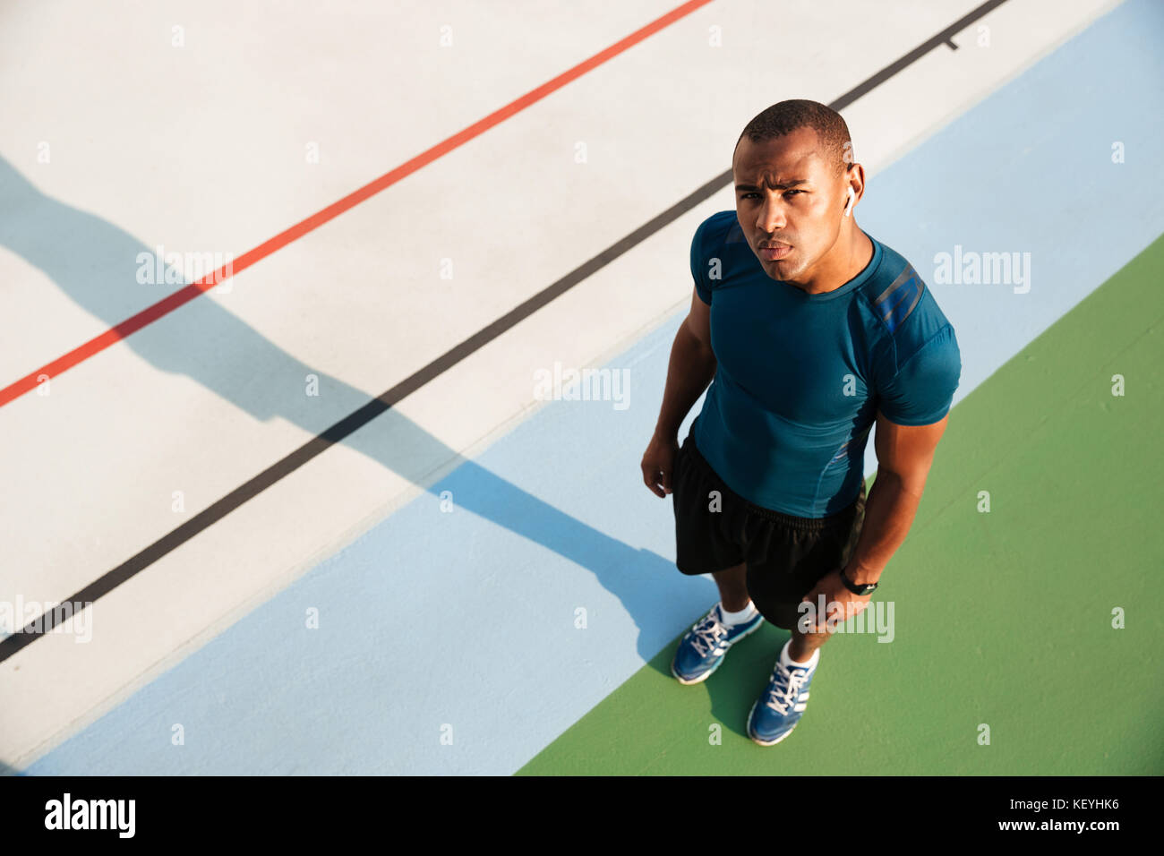 Top view portrait of a muscular afro american man standing on a track