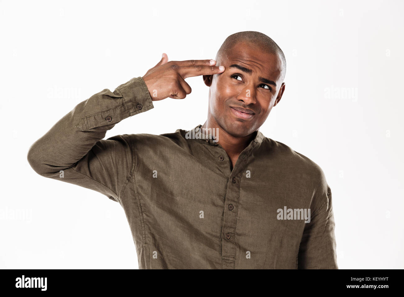 Handsome african man holding arm in gun gesture near the head and looking away over white background Stock Photo