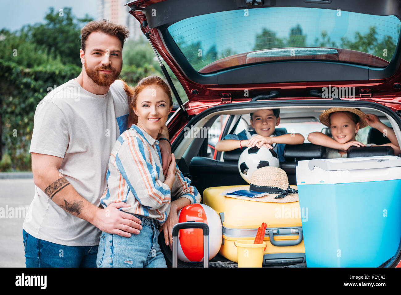 family packing luggage in car trunk Stock Photo Alamy