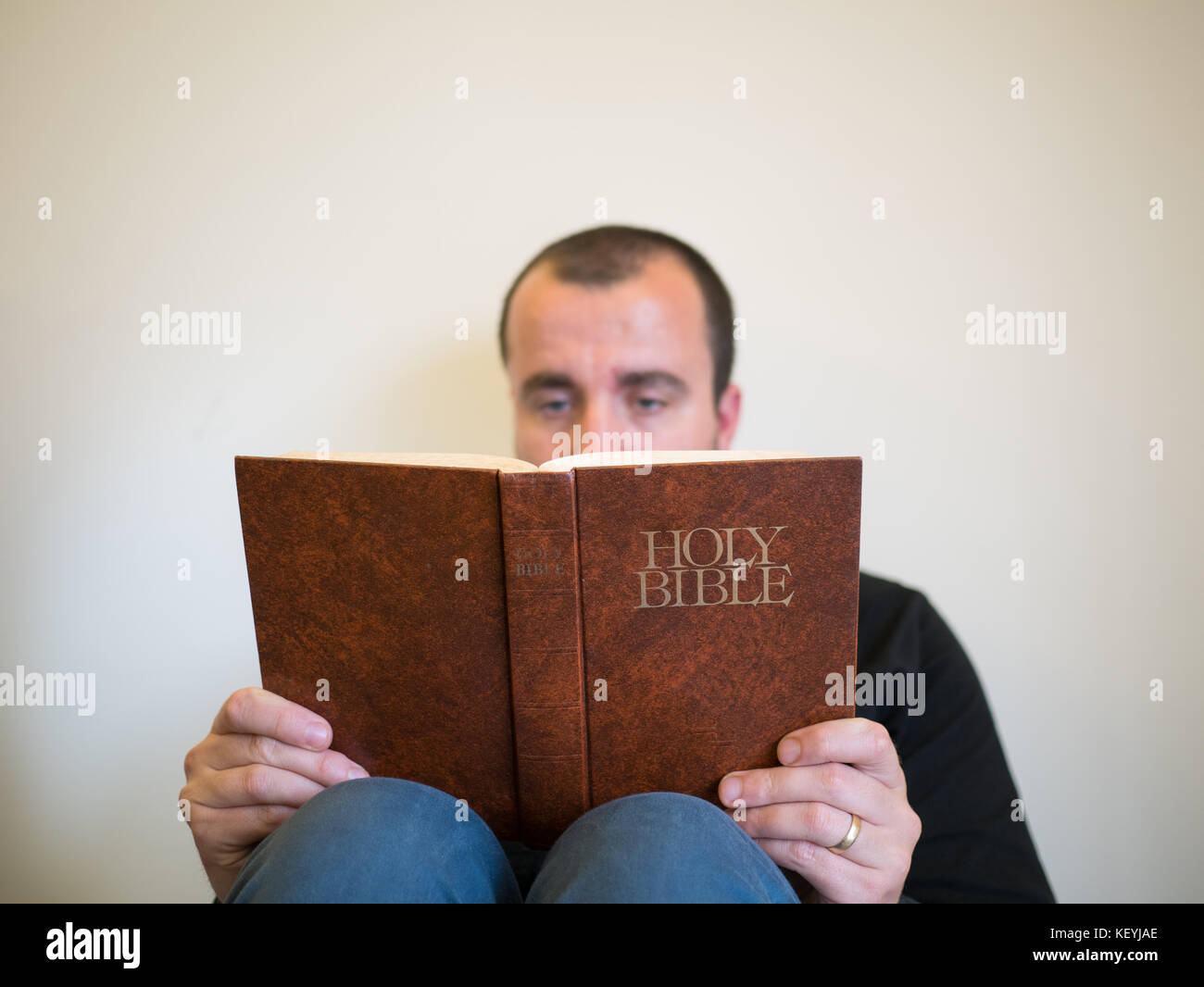 Man reading bible on white background Stock Photo
