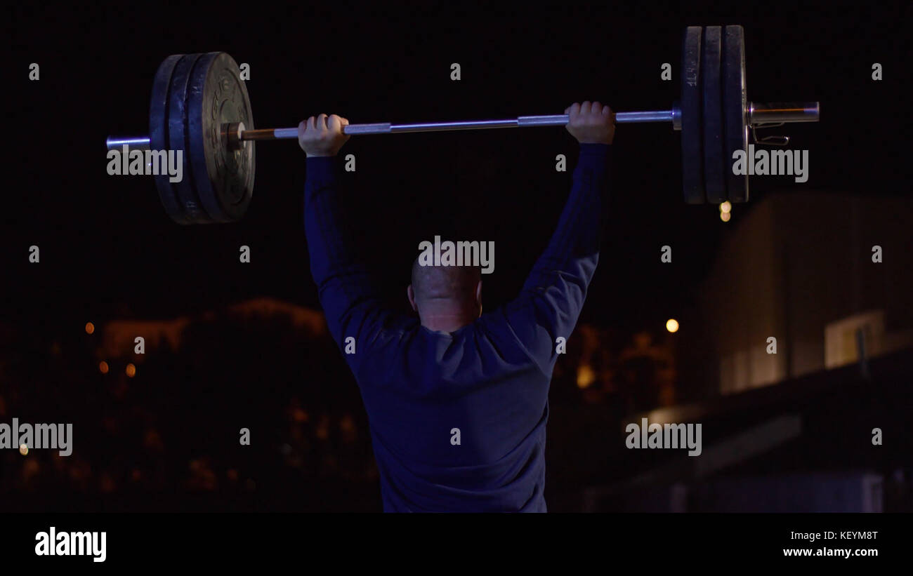 Weightlifter lifts the bar above his head. Strength training with a