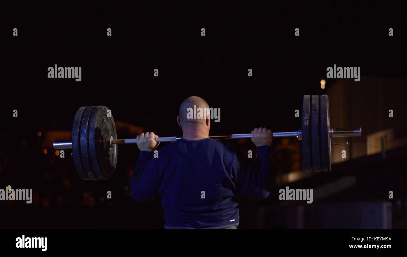 Weightlifter lifts the bar above his head. Strength training with a
