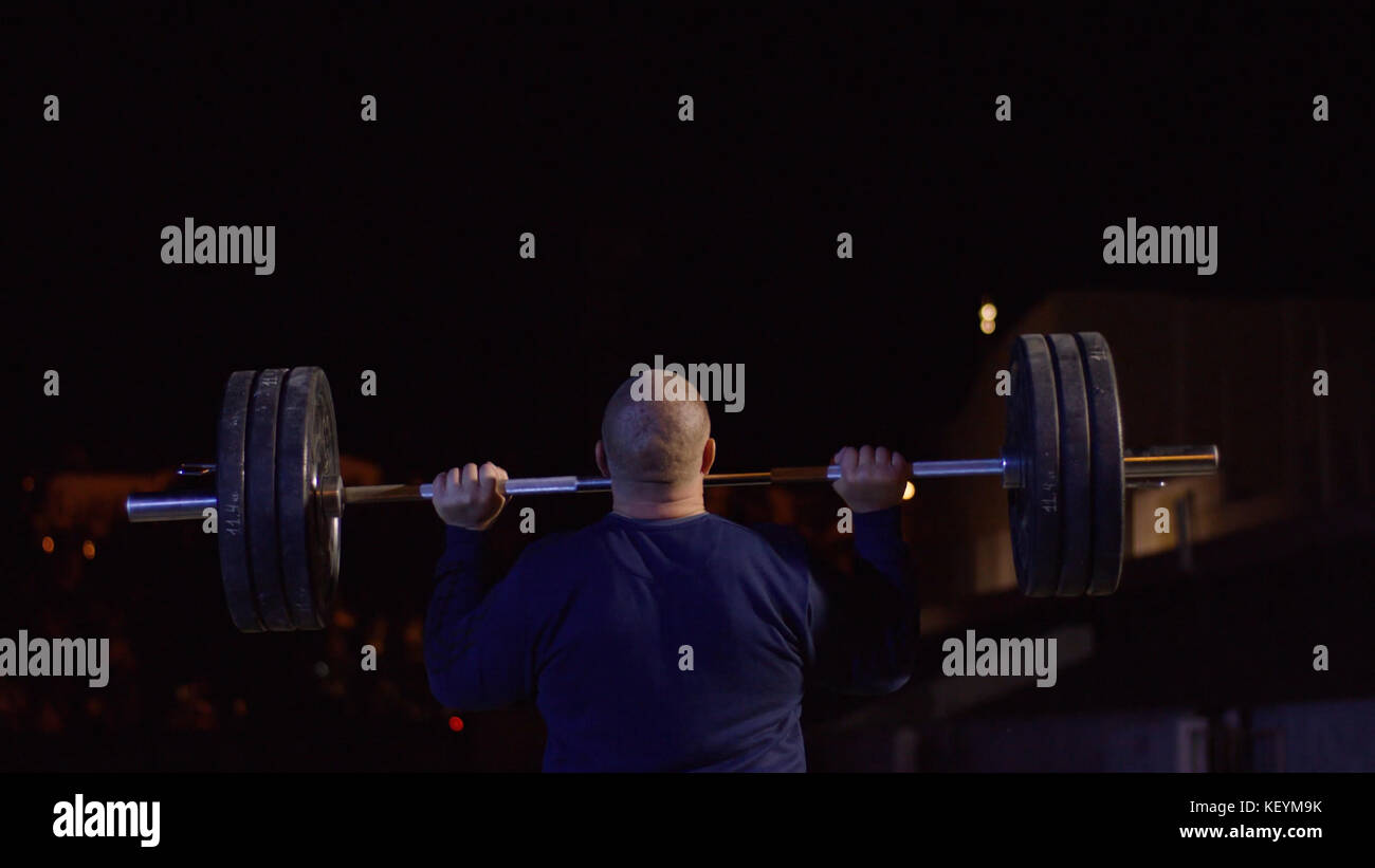 Weightlifter lifts the bar above his head. Strength training with a