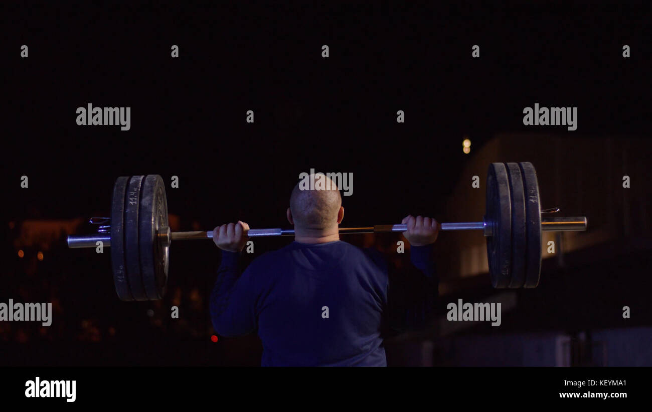 Weightlifter lifts the bar above his head. Strength training with a