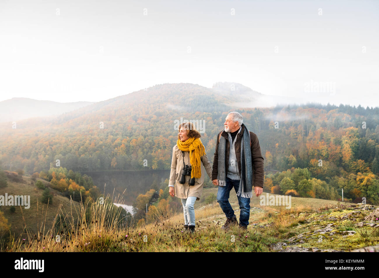 Active senior couple on a walk in a beautiful autumn nature Stock Photo ...
