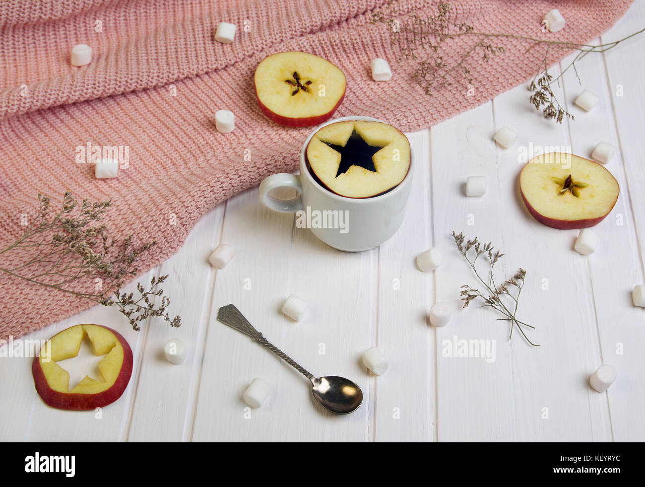 Cup of tea with star-cut apple inside on white background Stock Photo