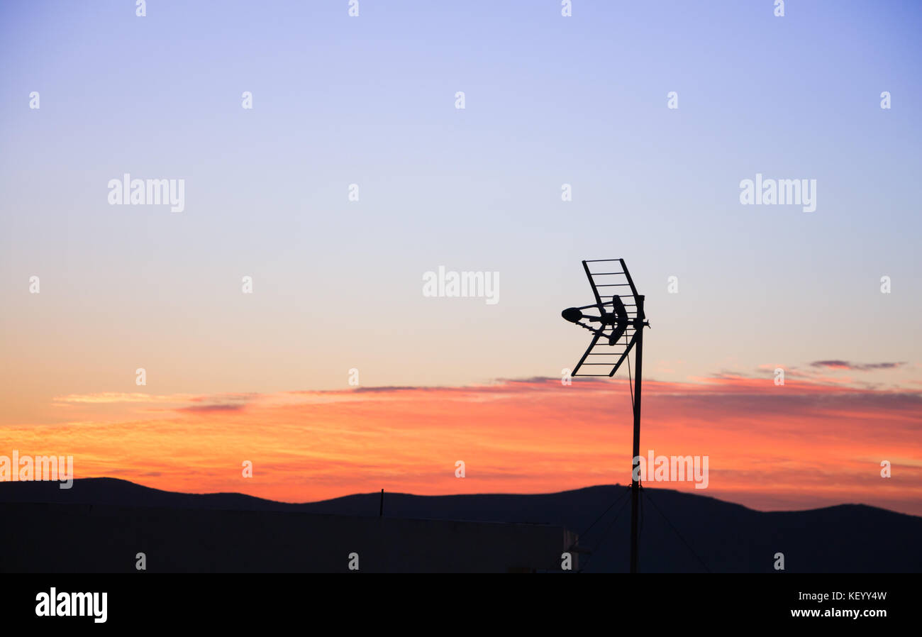 An old antenna silhouette against beautiful sunrise/sunset sky. Stock Photo