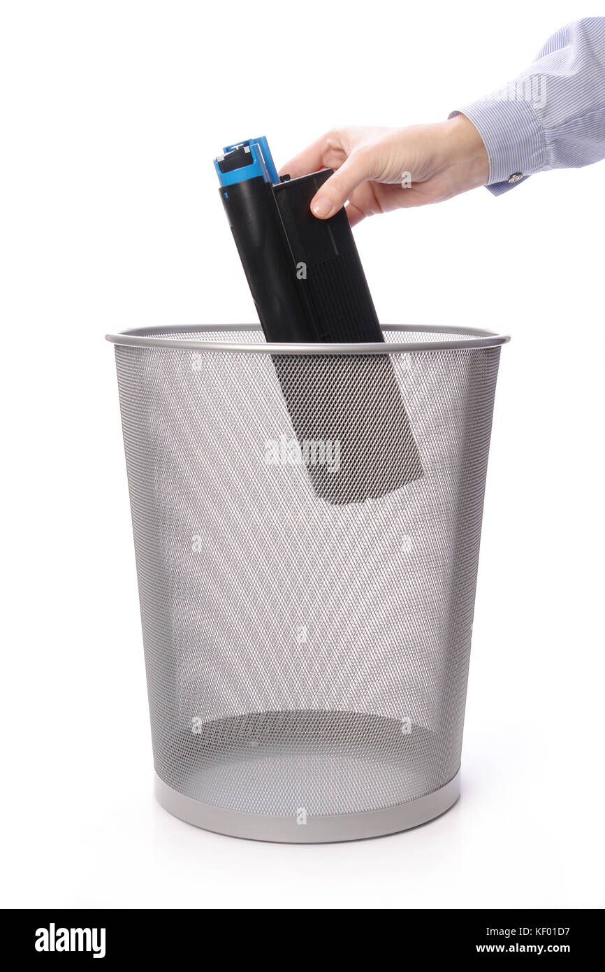 Female hand throwing used laser printer cartridge into metal trash bin
