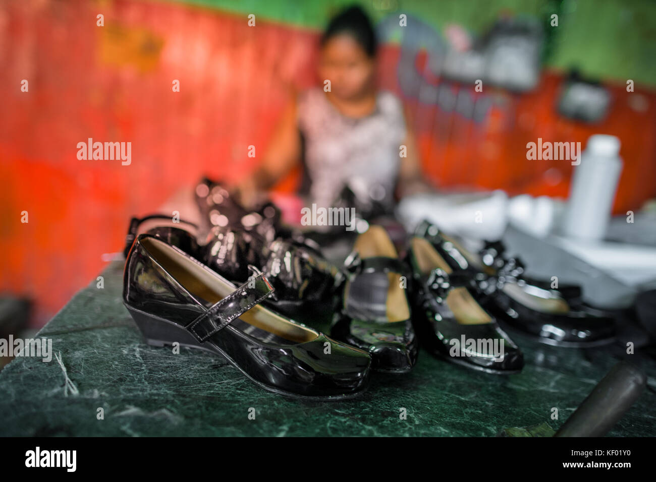 Newly made pairs of women’s patent leather shoes are seen placed on the table in a shoe making workshop in San Salvador, El Salvador, 16 November 2016 Stock Photo