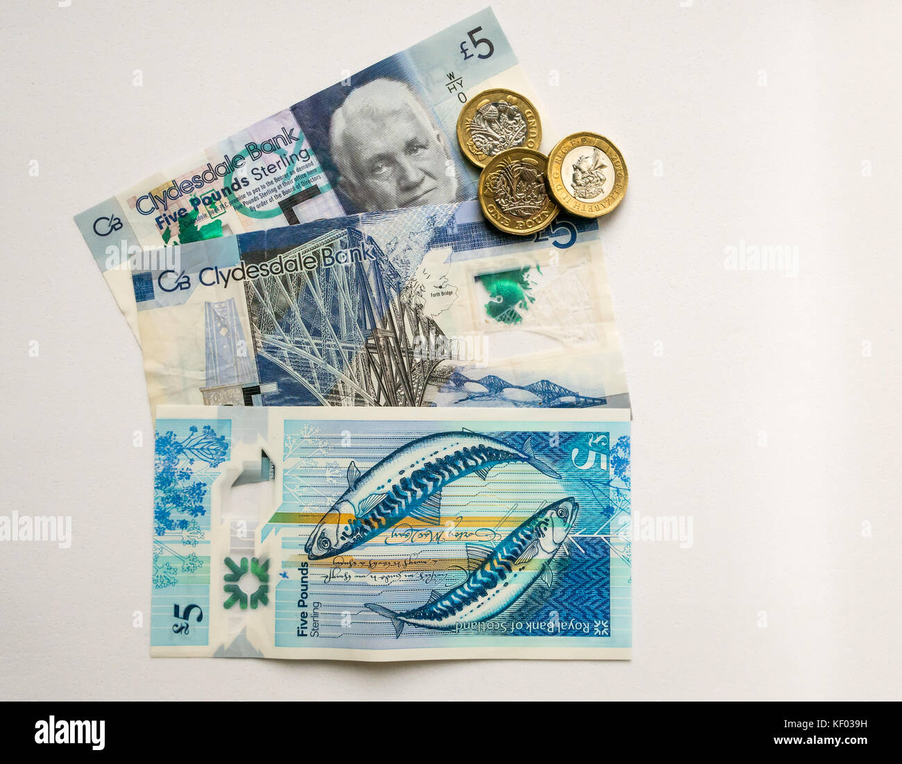 Hexagonal £1 coins and polymer Scottish £5 five pound banknotes, Clydesdale Bank and Royal Bank of Scotland, with two mackerels by artist Stuart Kerr Stock Photo