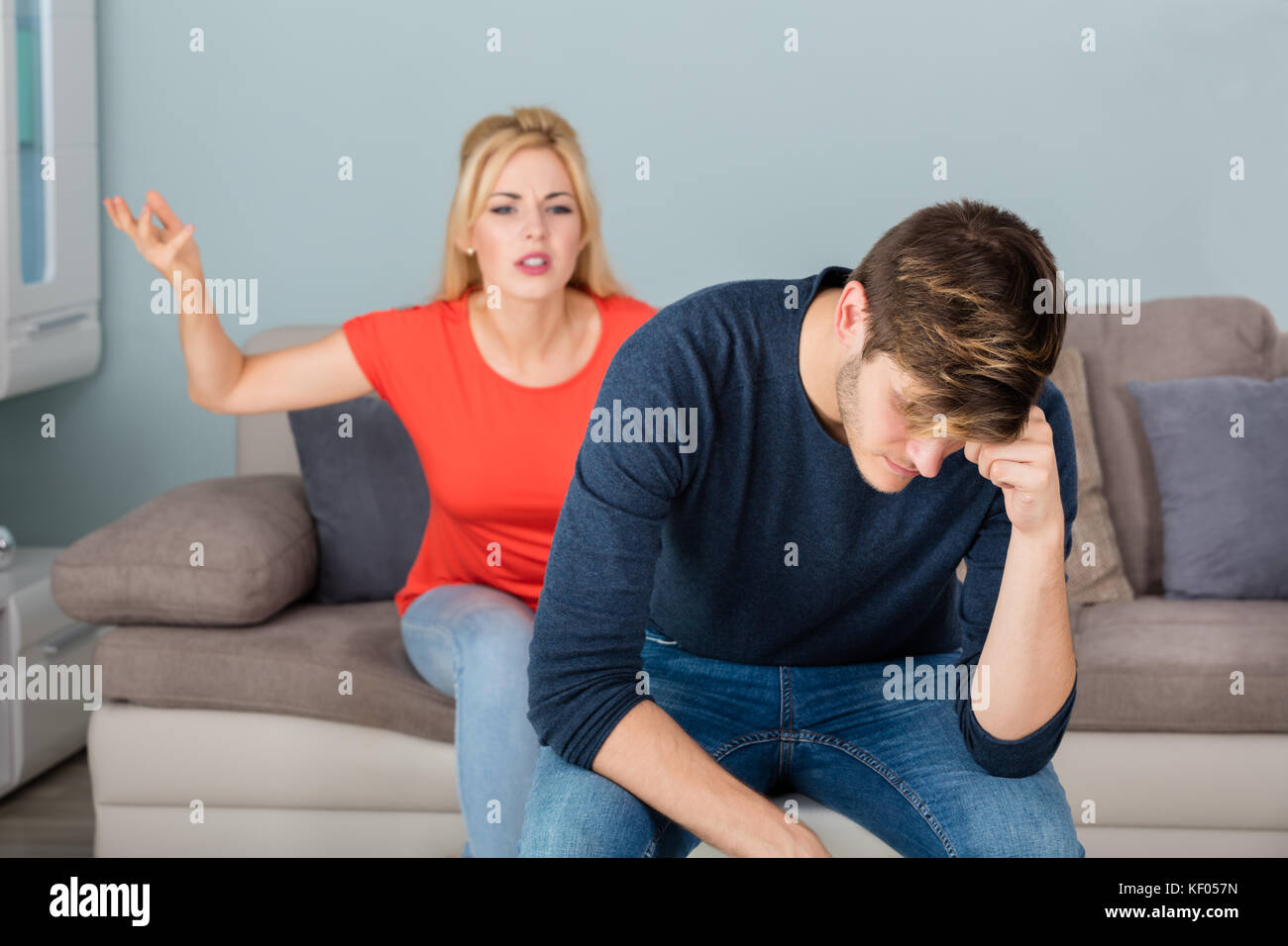 Depressed Divorcing Woman Sitting On Couch Having Argument With Man About Infidelity At Home Stock Photo