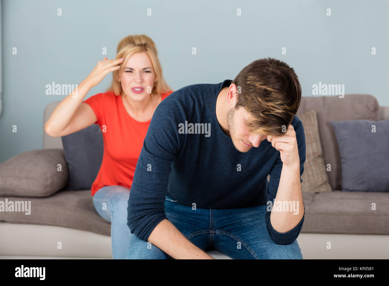 Unhappy Young Woman Sitting On Couch Having Arguing And Quarreling With Man At Home Stock Photo