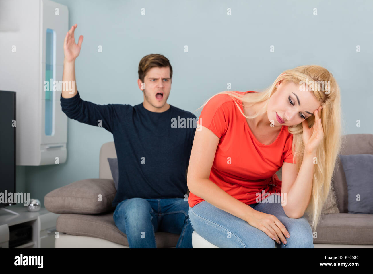 Angry Man Shouting To His Wife While Arguing About Infidelity And Divorce In Living Room Stock Photo