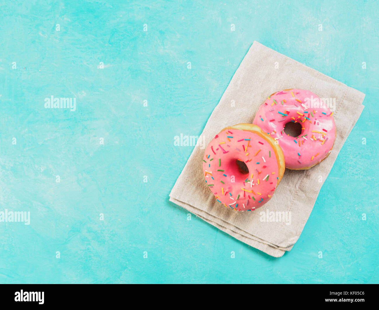 pink donuts on blue background , copy space, top view Stock Photo - Alamy
