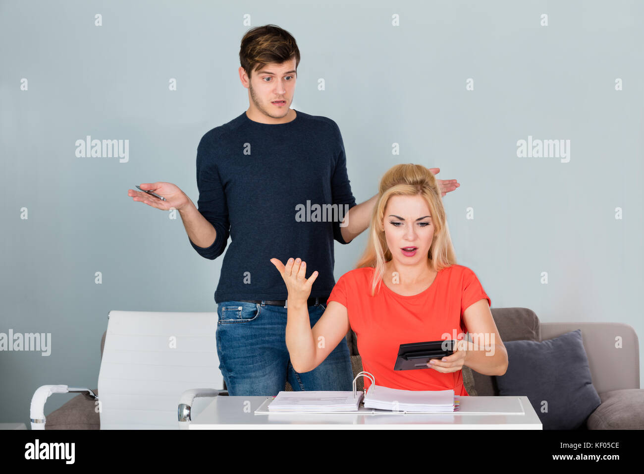 Shocked Young Couple Looking At Bills And Budget And No Money Left At Home Stock Photo