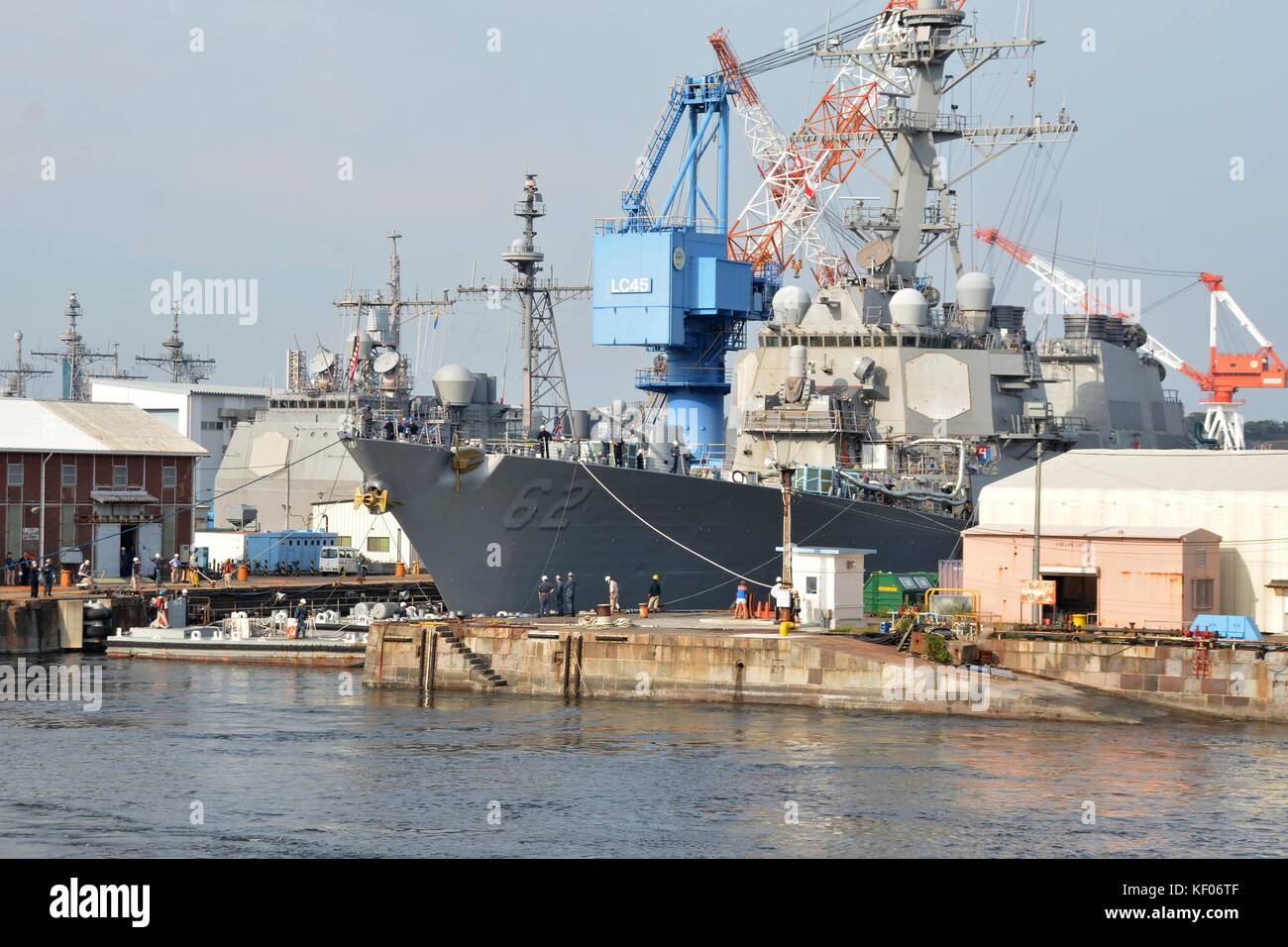 The U.S. Navy Arleigh Burke-class guided-missile destroyer USS Fitzgerald leaves the dry dock at Fleet Activities Yokosuka to undergo further repairs following its collision with a container ship October 8, 2017 in Yokosuka, Japan. Stock Photo