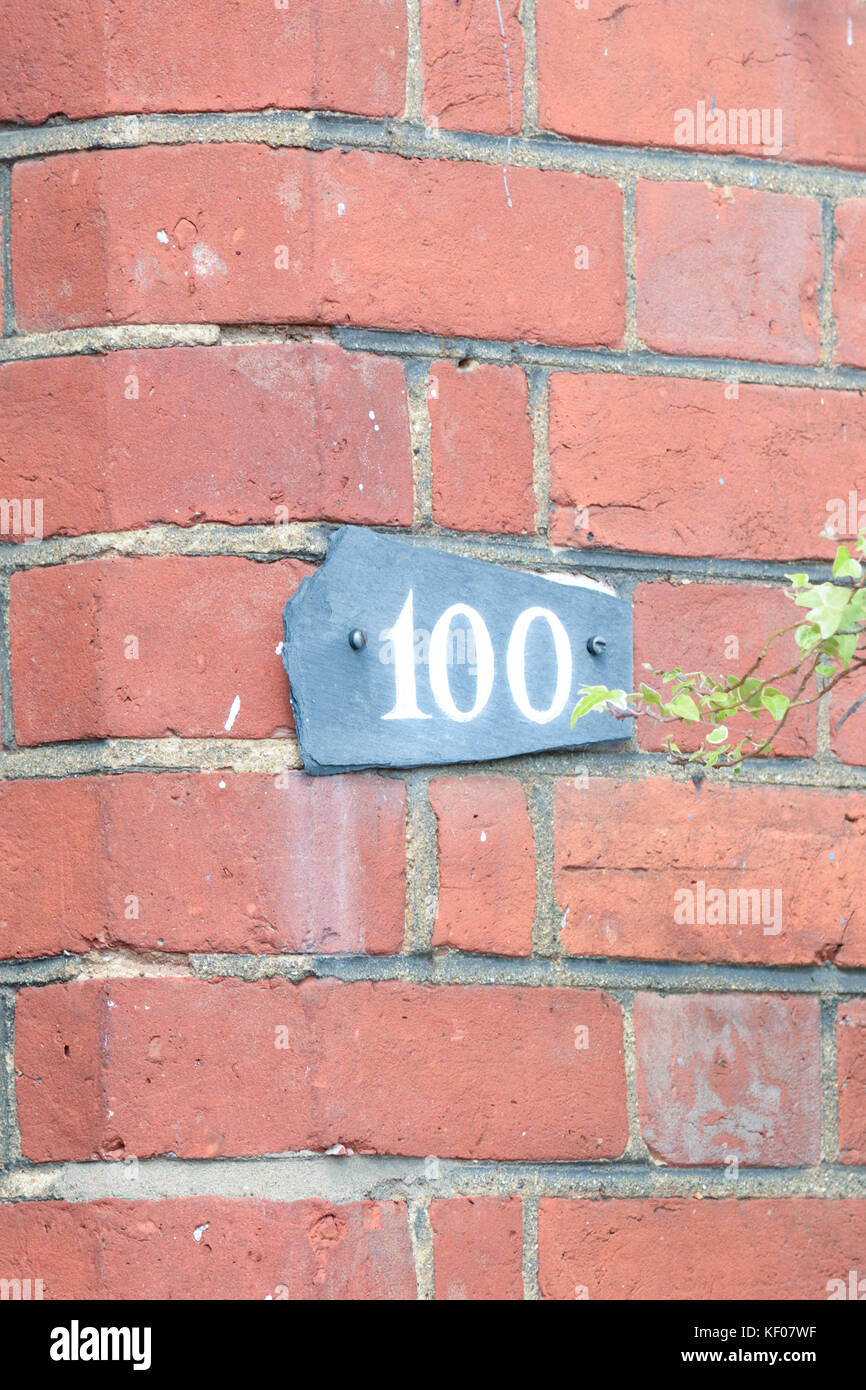 House number 100 sign on wall Stock Photo Alamy