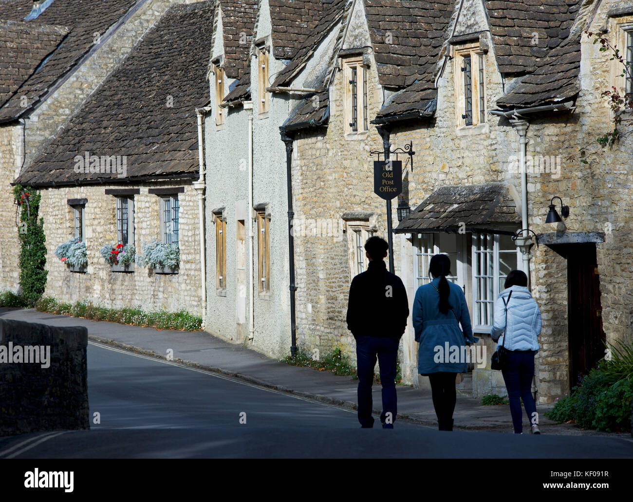 Three Asian tourists exploring the village of Castle Combe, Wiltshire, England UK Stock Photo