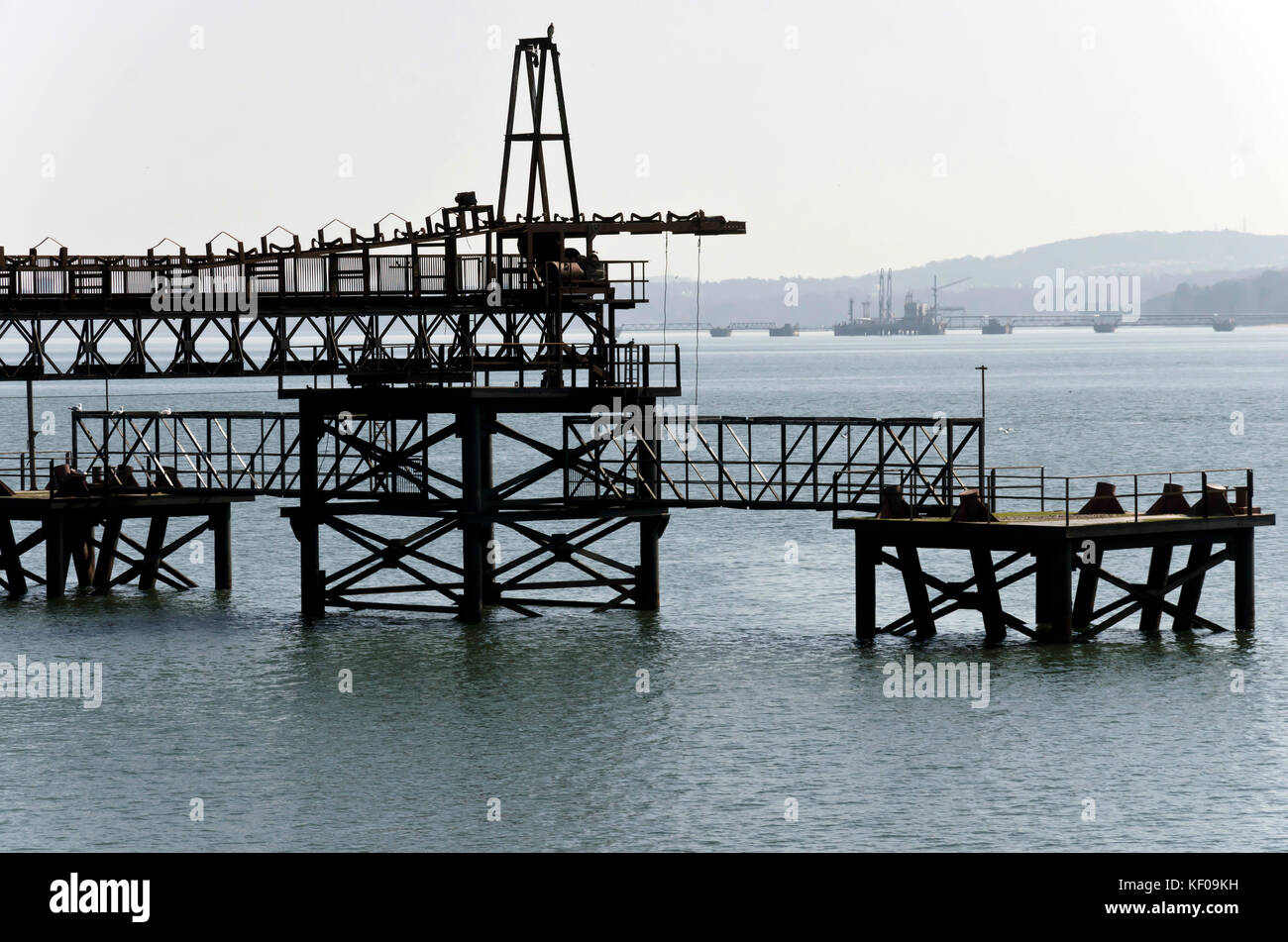 The remains of an old coal-loading pier near Inverkeithing on the Fife coast in Scotland, UK with Hound Point, an oil tanker pier beyond. Stock Photo