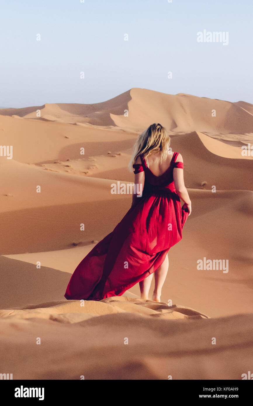 Woman in red dress in the Sahara Stock Photo