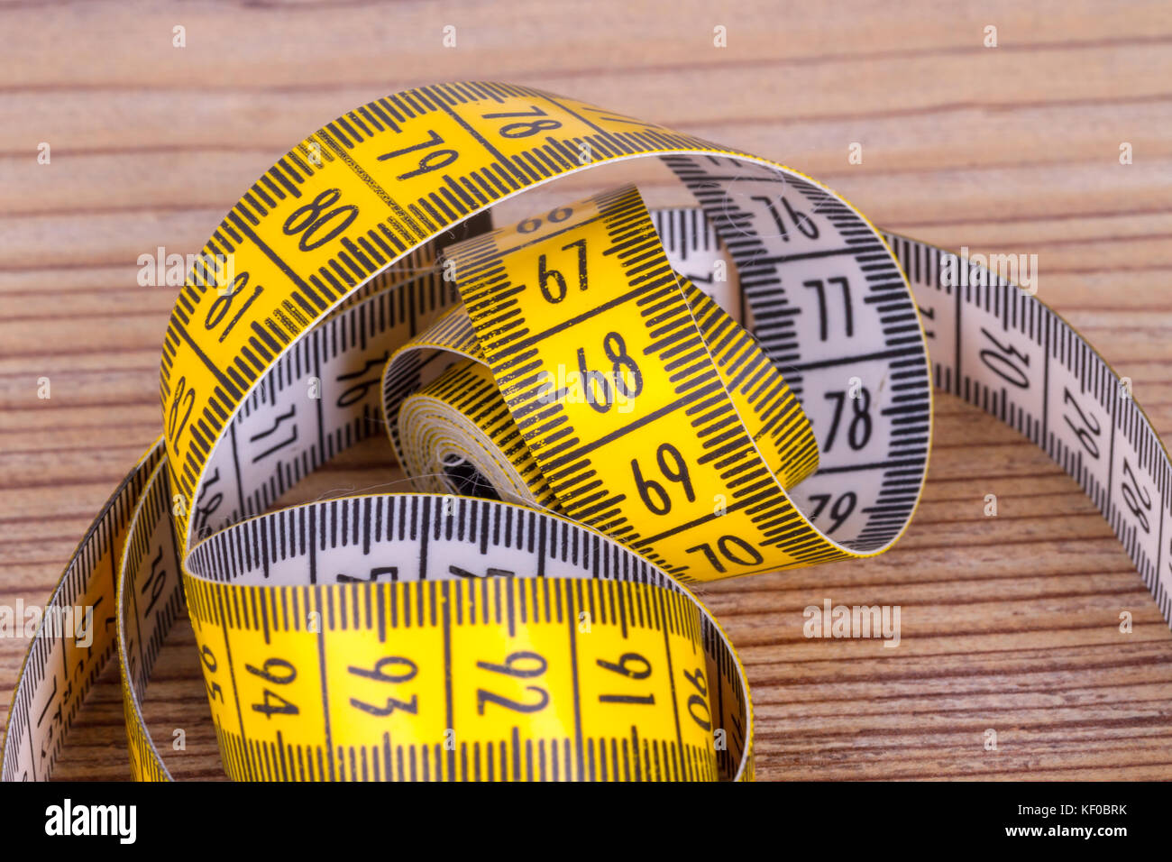 A Close Up Of A Yellow Metric Tape Measure With A White Hand