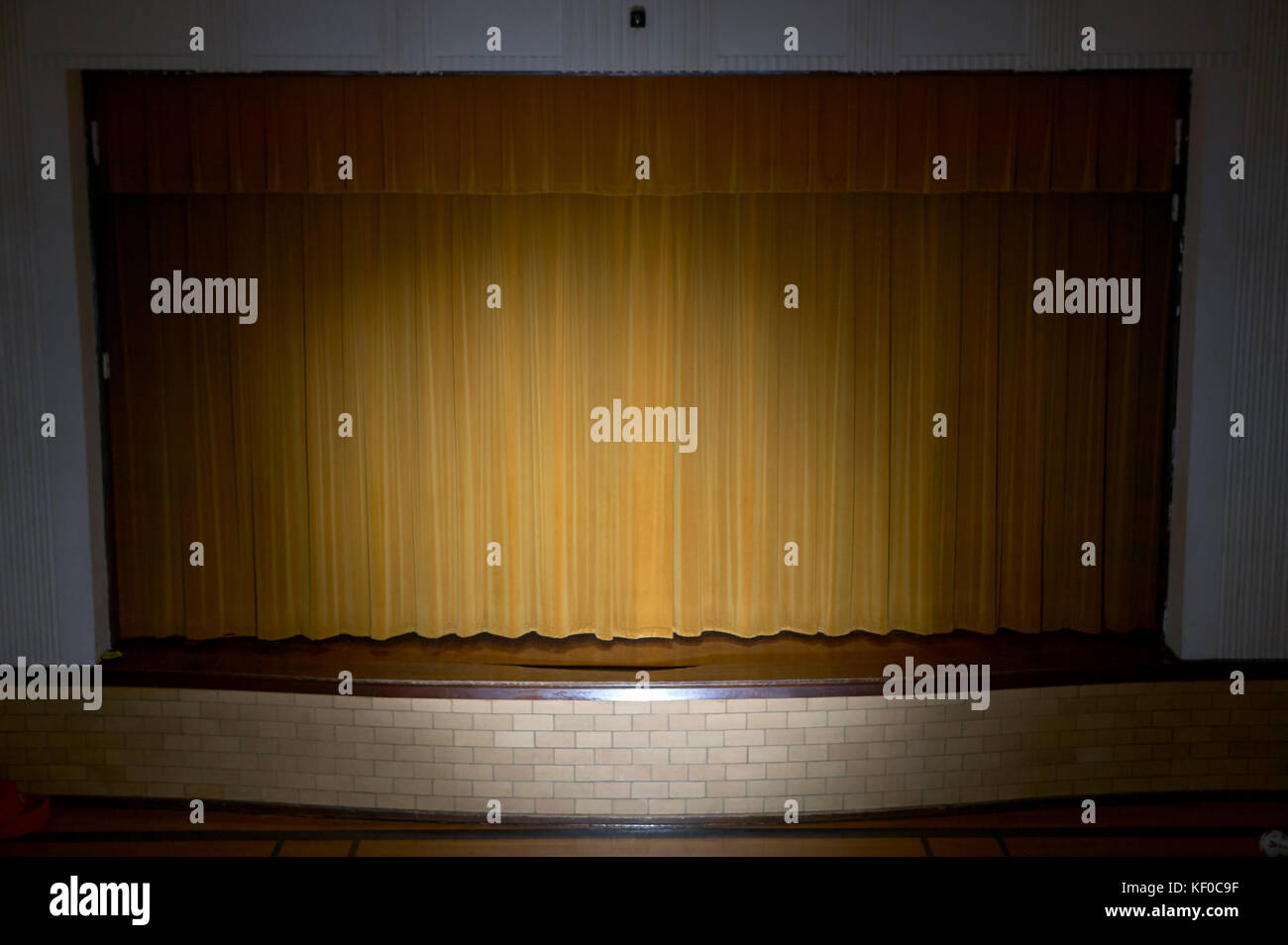 Drawn retro style curtains on a school performance stage lit by spotlight  with no people Stock Photo - Alamy