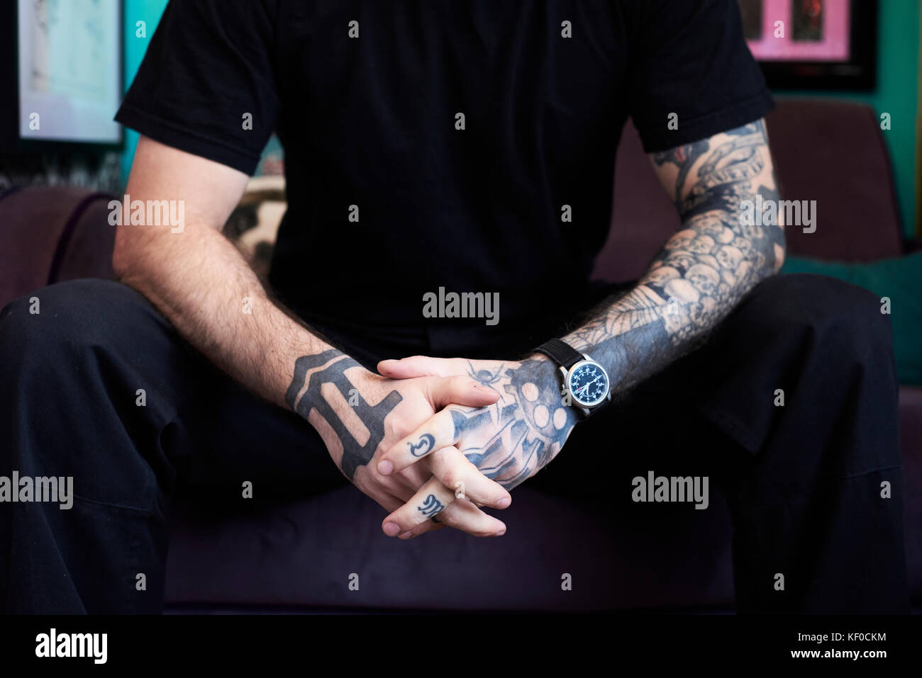 London, UK, Tattoo artist sitting on a purple bench on his shop, tattooist Stock Photo