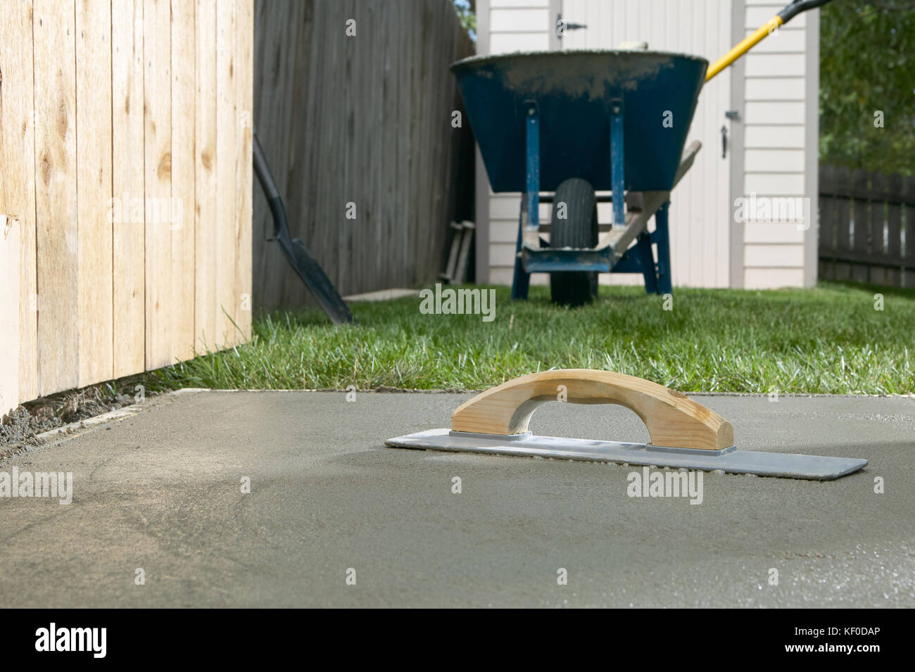 A cement screed resting on a finished concrete slab in backyard, DIY