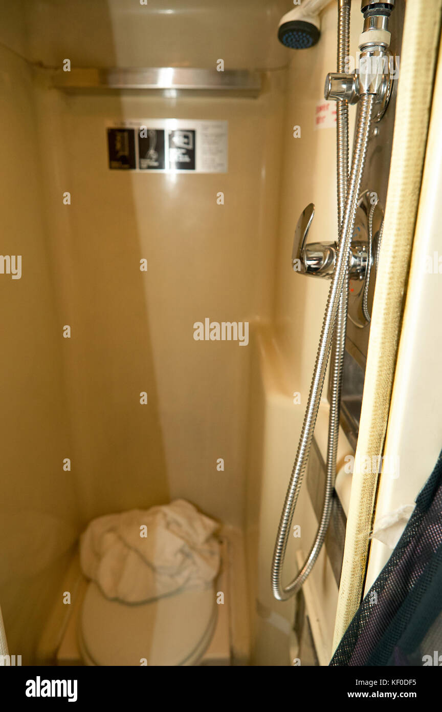 Interior view of an amtrak small bathrooom with a tall shower and small