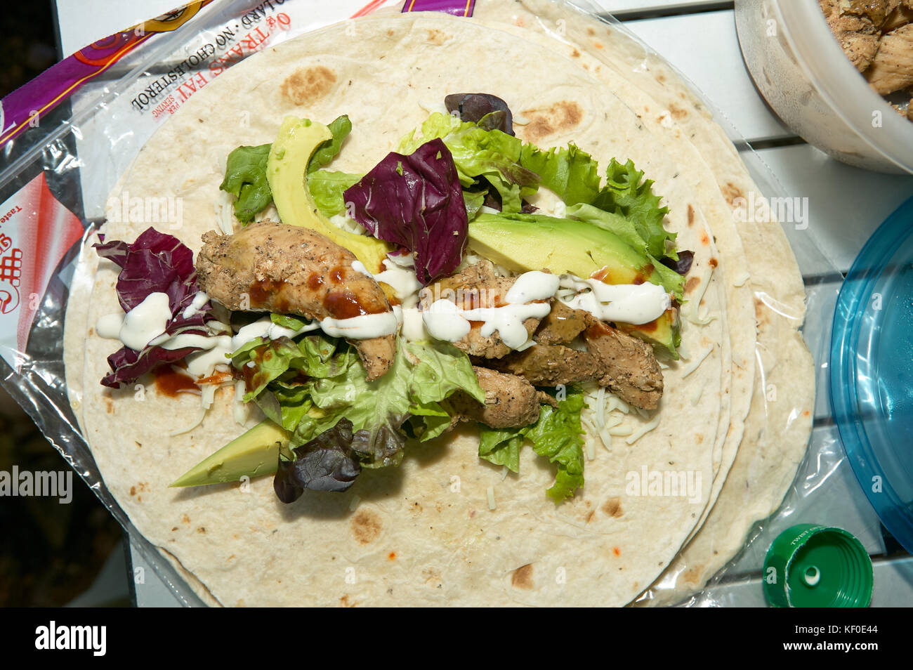 Ingredients for a corn tortilla or taco with meat mayonnaise, avocado pear lettuce and cabbage on prepackaged tortillas from a supermarket Stock Photo