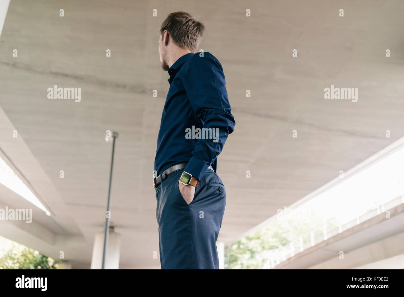 Businessman standing at underpass looking around Stock Photo