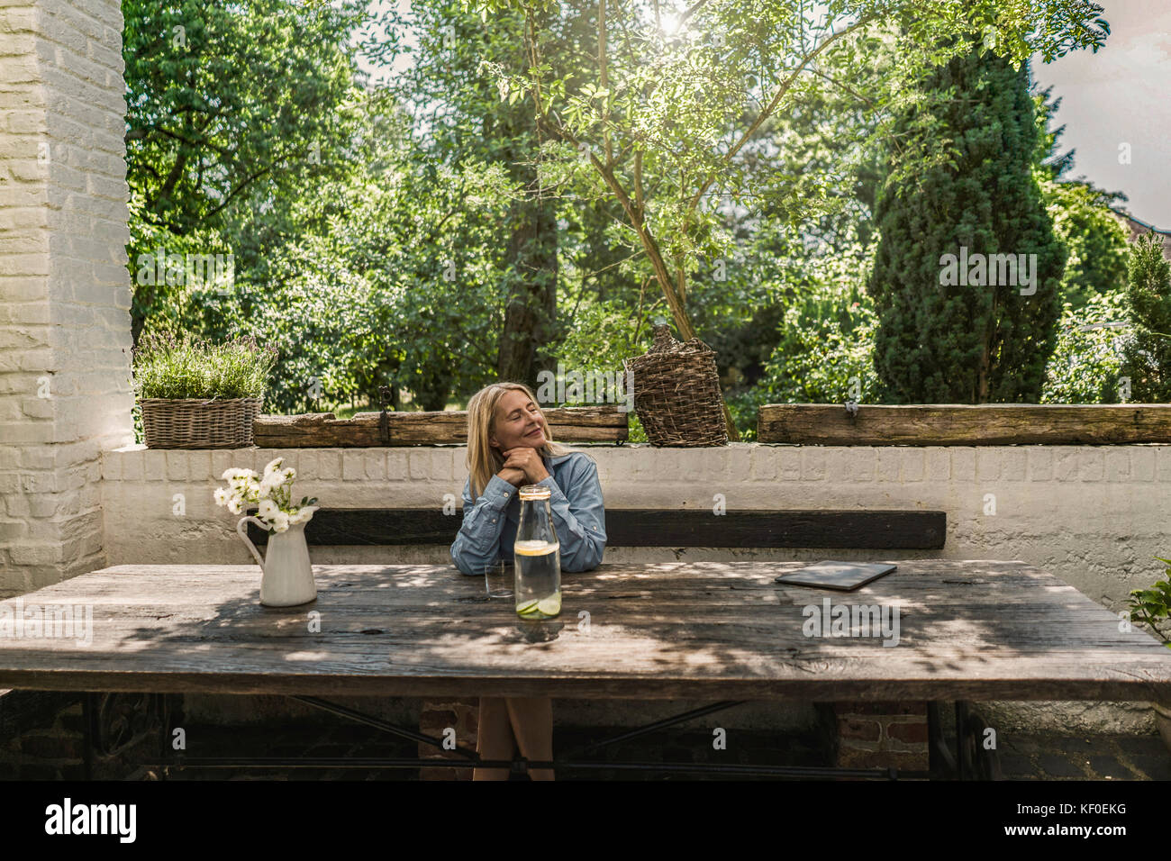 Mature woman sitting on terrace, enjoying summer Stock Photo - Alamy