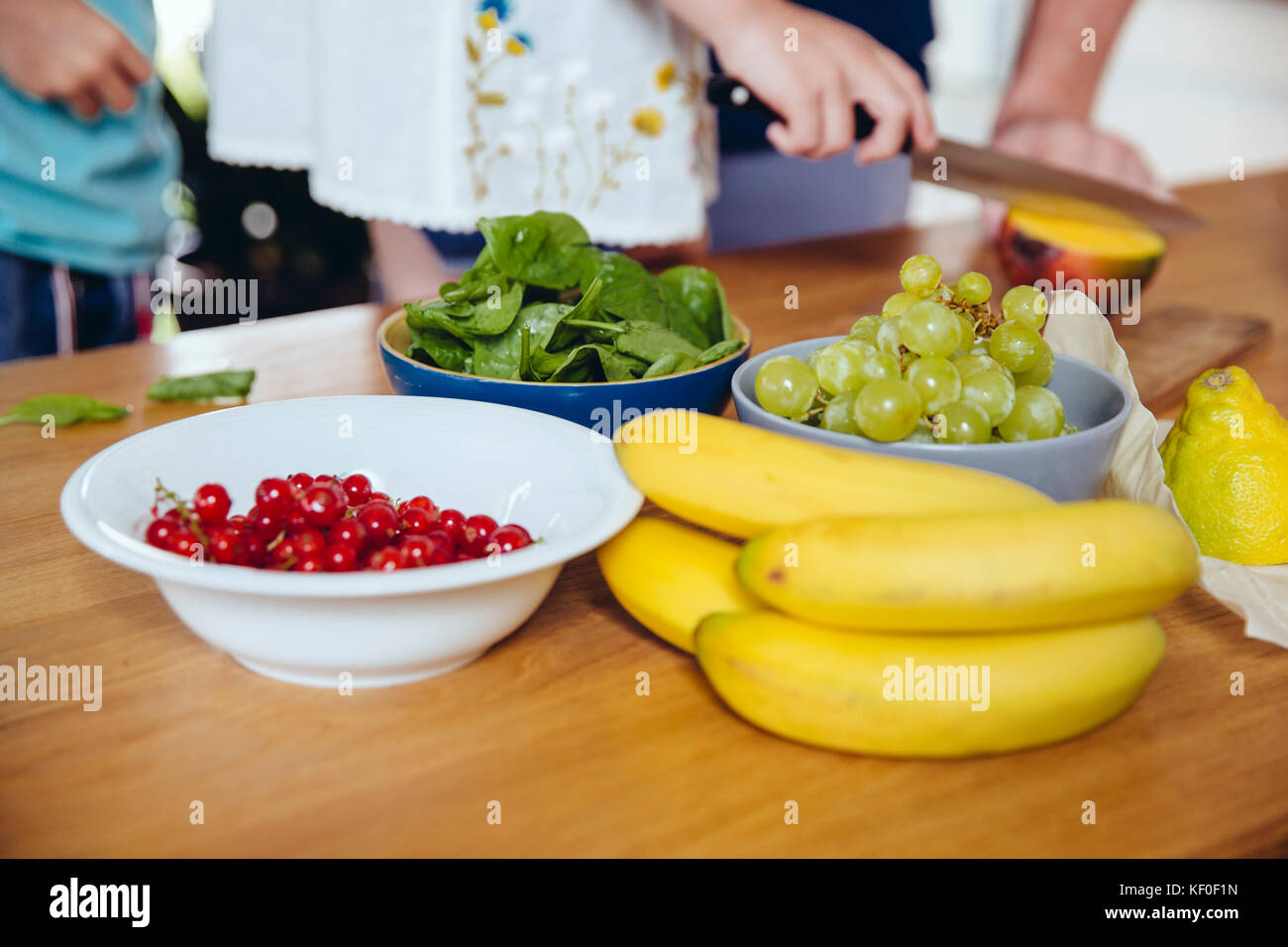 Close-up of family cutting fruit on kitchen counter Stock Photo