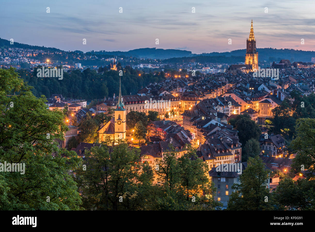 Switzerland, Bern, cityscape with lighted Nydeggkirche and minster at evening twilight Stock Photo