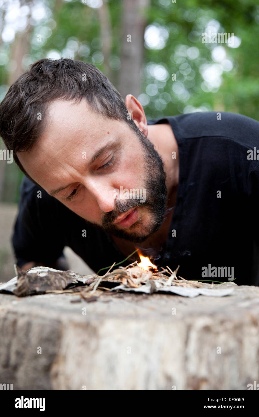 Man igniting a fire on tree stump in the forest Stock Photo Alamy